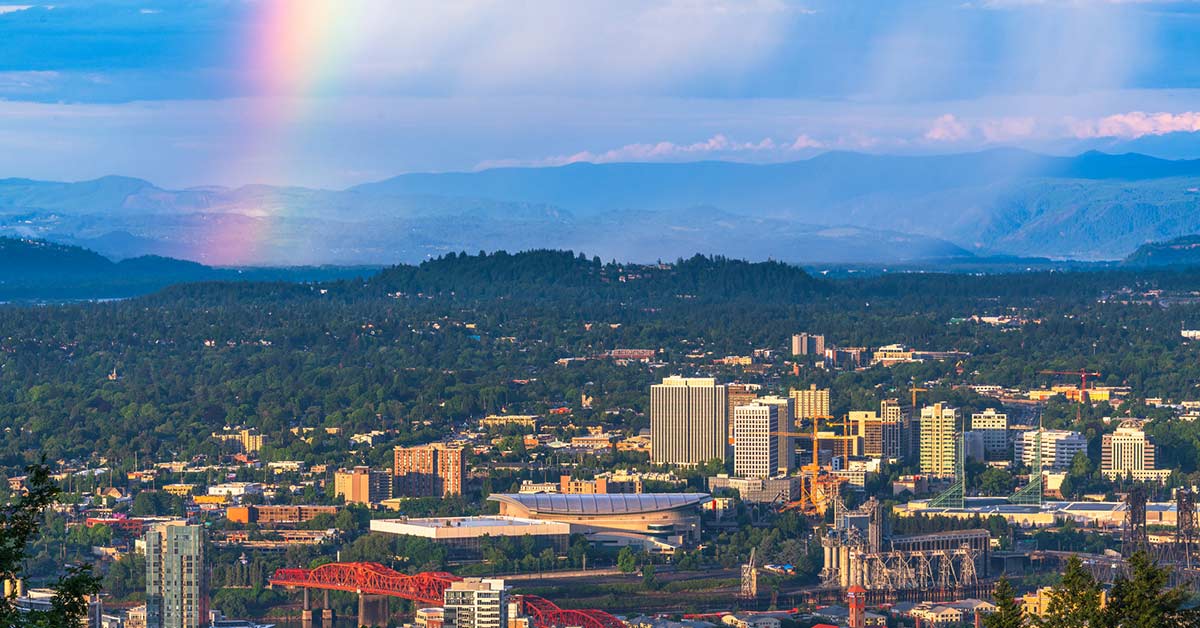 Portland skyline beneath changing weather conditions, highlighting how temperature swings, moisture, and overnight lows can impact exterior paint performance and curing.